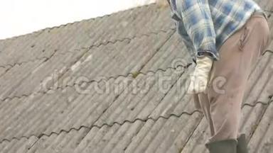 一位老人正在自己修屋顶. 石板上的旧木屋